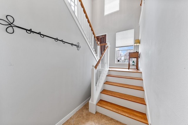 1708 Wilson St, Houston, TX 77019 - staircase with plenty of natural light, a high ceiling, baseboards, and tile patterned flooring