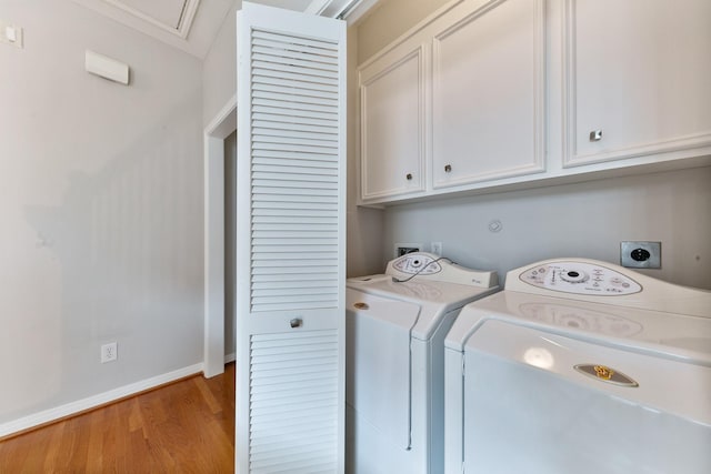 1708 Wilson St, Houston, TX 77019 - laundry room with cabinet space, washing machine and dryer, light wood-style floors, and baseboards