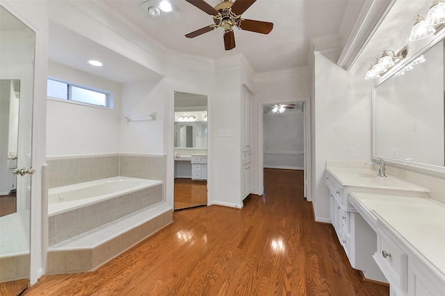 full bathroom with a ceiling fan, crown molding, vanity, a bath, and wood finished floors