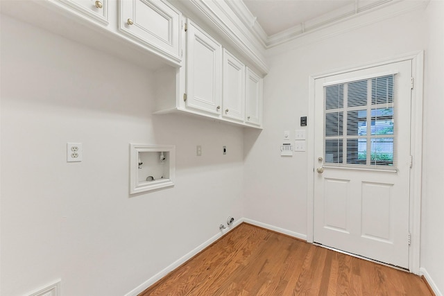 washroom with hookup for a washing machine, hookup for an electric dryer, crown molding, cabinet space, and light wood finished floors