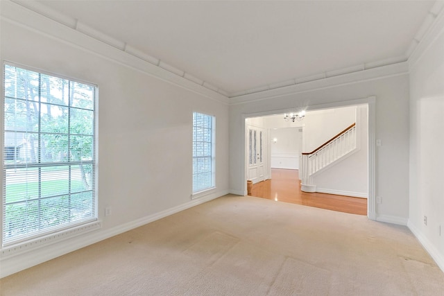 carpeted spare room with stairs, a chandelier, and baseboards