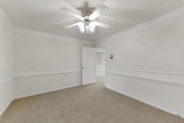 unfurnished room with light carpet, crown molding, a ceiling fan, and baseboards