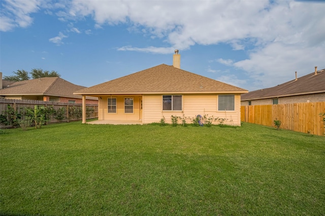 rear view of house with a chimney, a patio, and a shingled roof