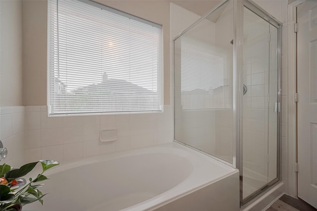 full bathroom featuring a garden tub and a shower stall