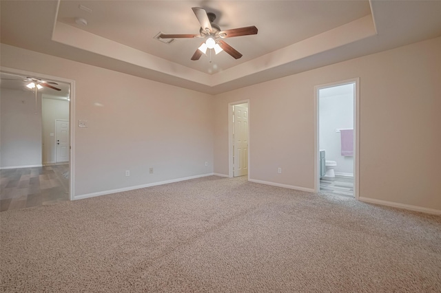 unfurnished room featuring a ceiling fan, a raised ceiling, light carpet, and baseboards