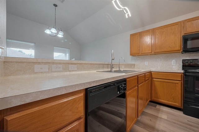 kitchen with black appliances, a sink, lofted ceiling, light wood finished floors, and light countertops