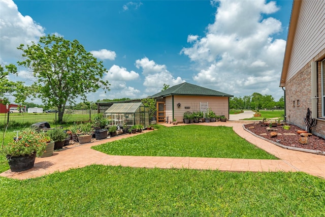 11413 7th St, Santa Fe, TX 77510 - view of grassy yard featuring a greenhouse, an outbuilding, and a vegetable garden