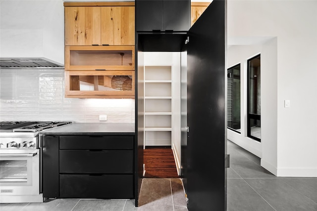 kitchen with stainless steel range, wall chimney range hood, decorative backsplash, tile patterned floors, and modern cabinets