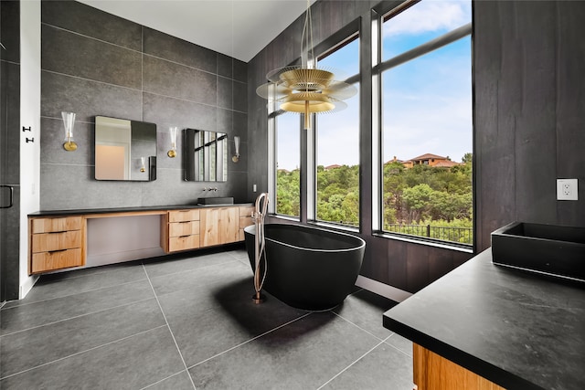 full bath featuring vanity, tile patterned floors, and a freestanding bath