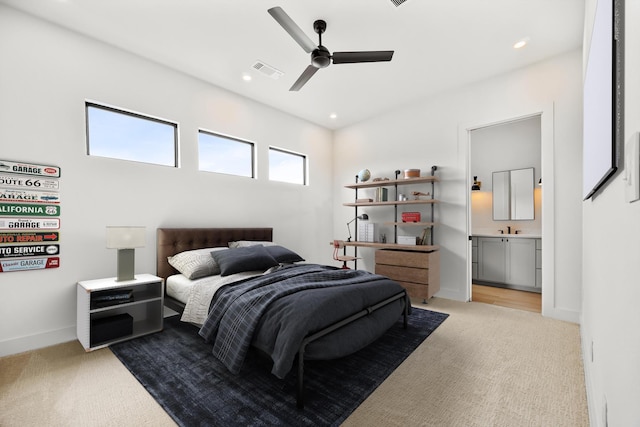 bedroom featuring light carpet, ensuite bathroom, baseboards, recessed lighting, and a ceiling fan