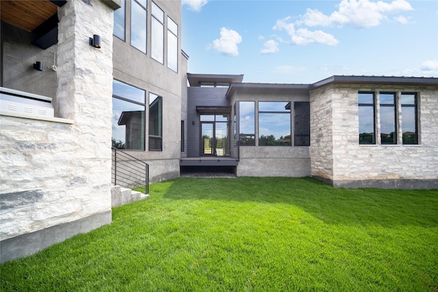back of house with a yard and stone siding