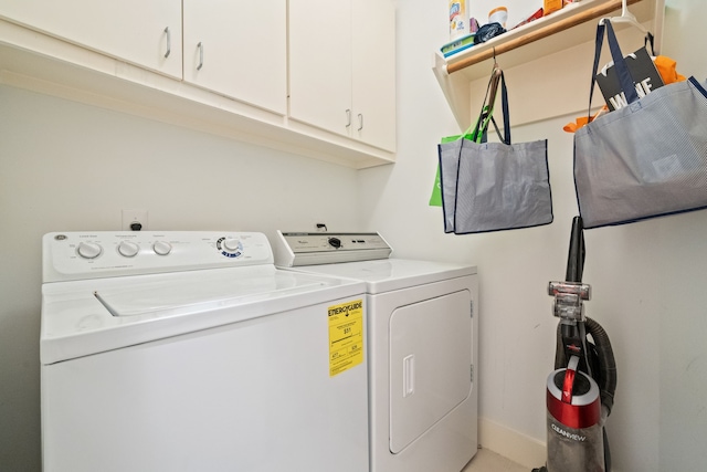 washroom with washing machine and dryer and cabinet space