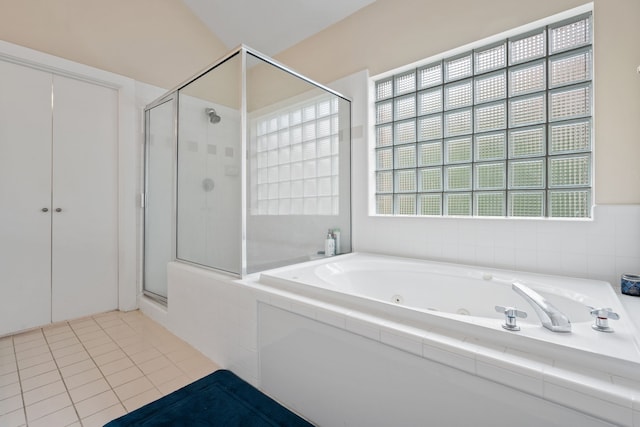 bathroom featuring a shower stall, a tub with jets, and tile patterned flooring