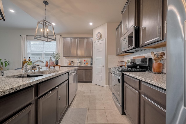 4314 Reese Ravine Ln, Katy, TX 77493 - kitchen featuring stainless steel appliances, a sink, decorative backsplash, a chandelier, and pendant lighting