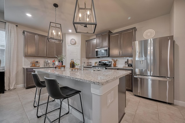 4314 Reese Ravine Ln, Katy, TX 77493 - kitchen with appliances with stainless steel finishes, tasteful backsplash, light tile patterned floors, light stone countertops, and recessed lighting