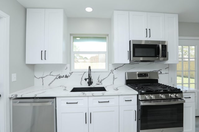 5506 Karelian Dr, Houston, TX 77091 - kitchen with appliances with stainless steel finishes, a sink, light stone counters, tasteful backsplash, and recessed lighting