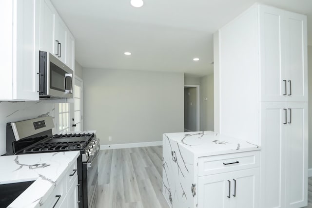 5506 Karelian Dr, Houston, TX 77091 - kitchen featuring appliances with stainless steel finishes, white cabinets, light stone countertops, light wood finished floors, and recessed lighting