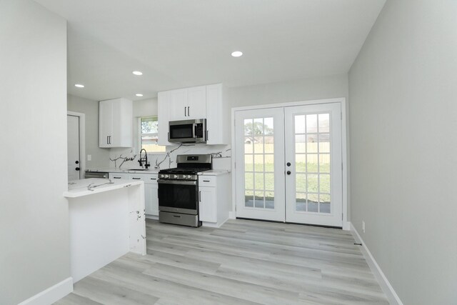 5506 Karelian Dr, Houston, TX 77091 - kitchen featuring stainless steel appliances, a sink, french doors, light countertops, and white cabinetry