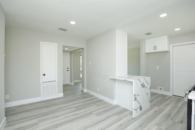 5506 Karelian Dr, Houston, TX 77091 - kitchen with white cabinets, light wood-type flooring, baseboards, light stone counters, and recessed lighting