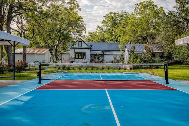 view of sport court featuring a tennis court and fence