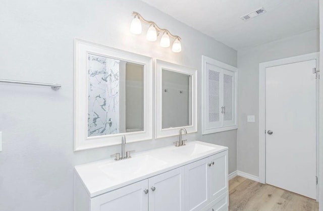 148 Seaside Ln, Texas City, TX 77590 - bathroom featuring wood finished floors, double vanity, and baseboards