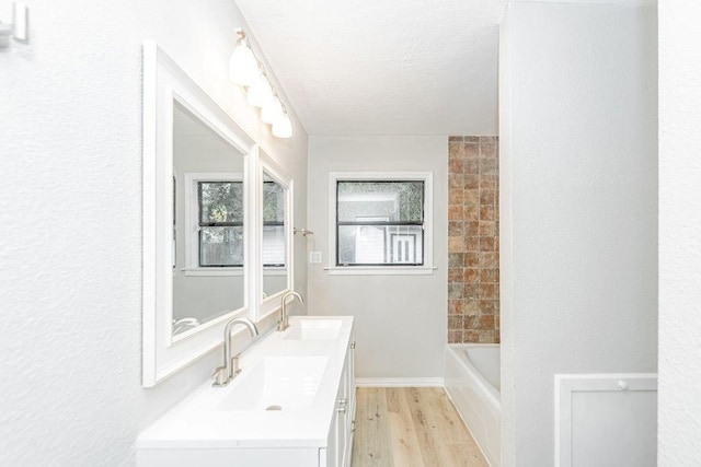 148 Seaside Ln, Texas City, TX 77590 - full bath featuring wood finished floors, double vanity, and a textured ceiling