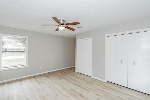 148 Seaside Ln, Texas City, TX 77590 - unfurnished bedroom with two closets, wood finished floors, baseboards, and ceiling fan