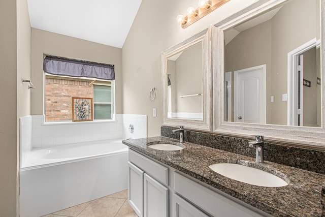 bathroom with lofted ceiling, tile patterned flooring, a garden tub, and double vanity