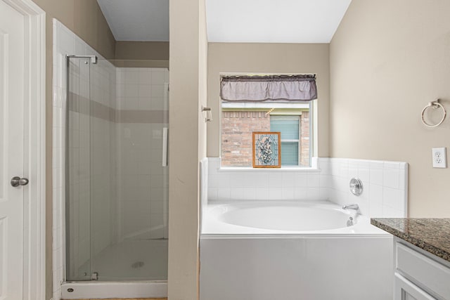 bathroom with a stall shower, vanity, and a garden tub