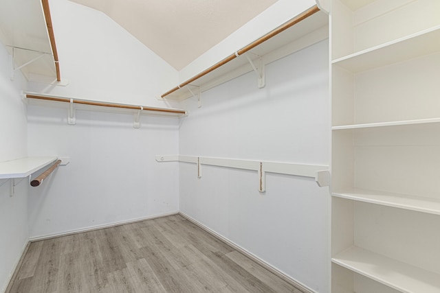 spacious closet featuring light wood-style flooring and vaulted ceiling