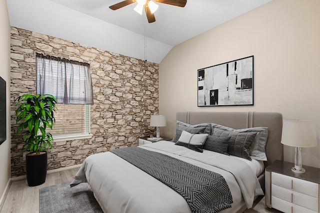bedroom with wood finished floors, vaulted ceiling, and a ceiling fan