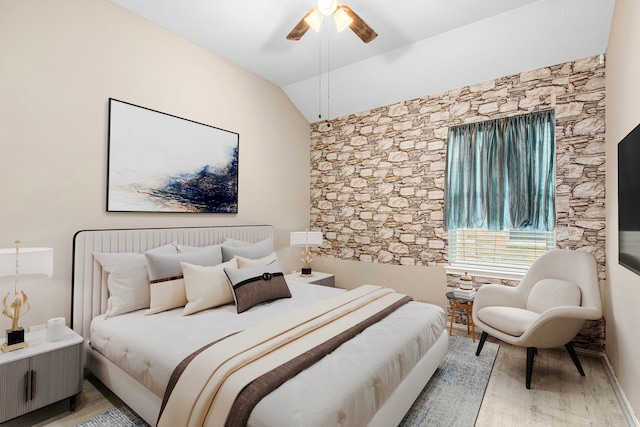 bedroom featuring light wood-type flooring, vaulted ceiling, and ceiling fan