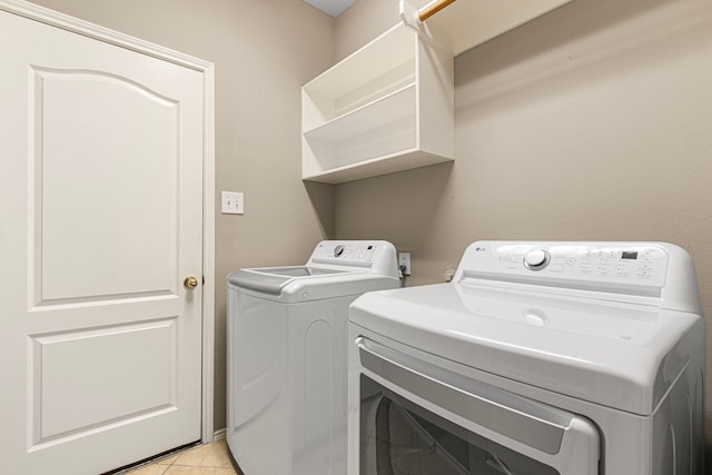 laundry room featuring washing machine and dryer and light tile patterned floors
