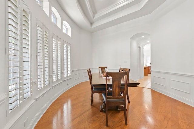 8611 Springmere Ct, Houston, TX 77095 - dining area featuring a decorative wall, plenty of natural light, arched walkways, crown molding, and light wood-style floors