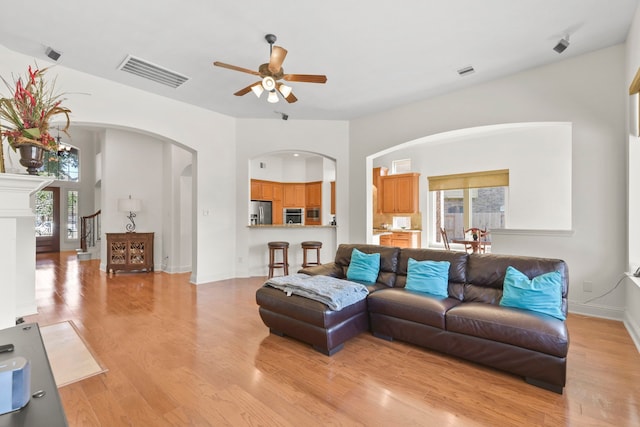 8611 Springmere Ct, Houston, TX 77095 - living area featuring ceiling fan, arched walkways, light wood finished floors, and baseboards