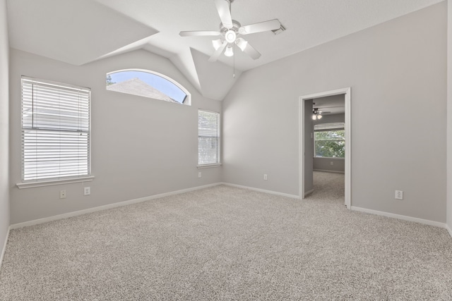 spare room with ceiling fan, vaulted ceiling, carpet floors, and baseboards