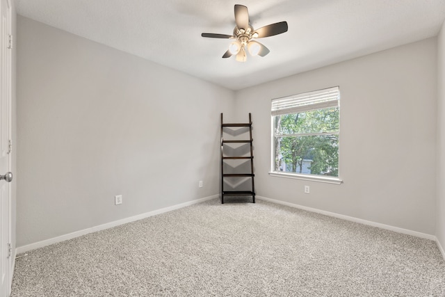 spare room with light colored carpet, ceiling fan, and baseboards