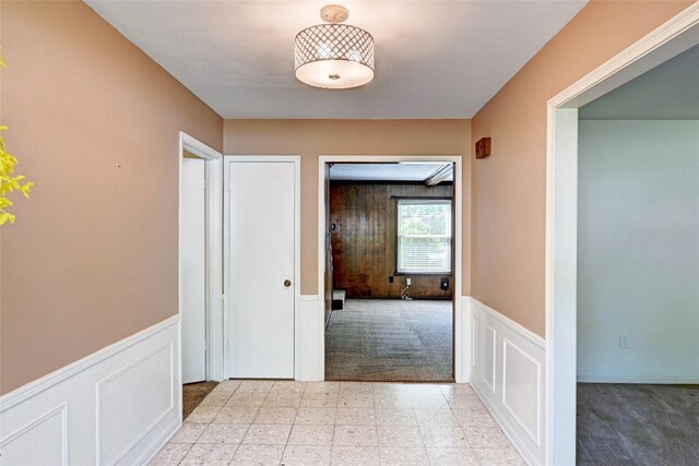 7907 Aleta Dr, Spring, TX 77379 - hallway featuring light carpet, a wainscoted wall, and a decorative wall