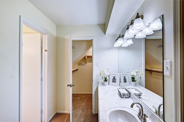 7907 Aleta Dr, Spring, TX 77379 - bathroom featuring a walk in closet, vanity, and baseboards