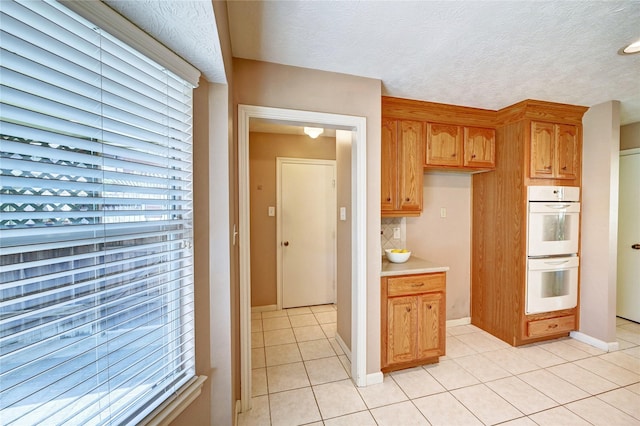 7907 Aleta Dr, Spring, TX 77379 - kitchen featuring white double oven, light tile patterned floors, light countertops, and healthy amount of natural light