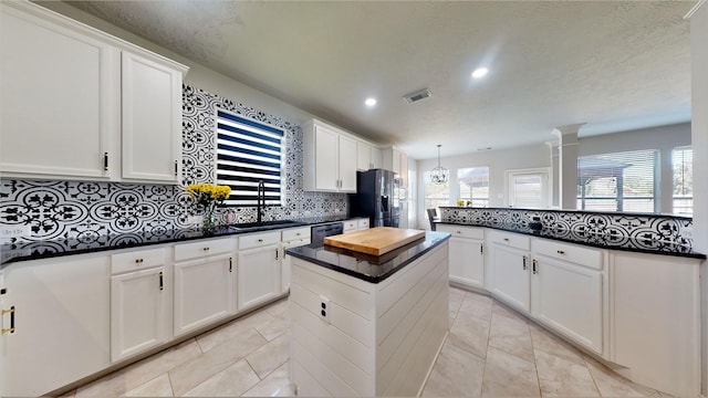 2506 Foxcrest Dr, Katy, TX 77494 - kitchen with appliances with stainless steel finishes, a sink, a kitchen island, decorative backsplash, and white cabinetry