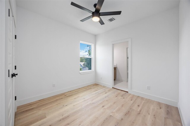 unfurnished bedroom with wood finished floors, baseboards, connected bathroom, and ceiling fan