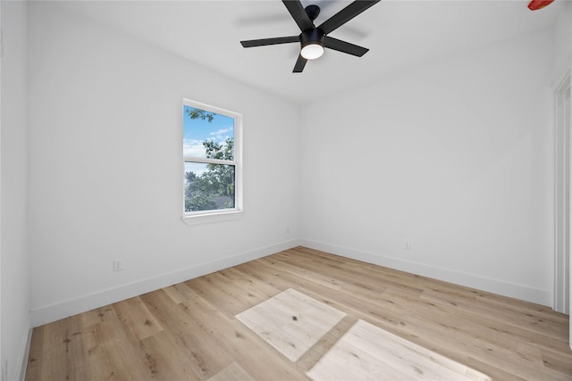 empty room featuring a ceiling fan, baseboards, and wood finished floors