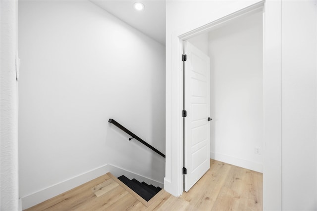 staircase with wood finished floors, recessed lighting, and baseboards