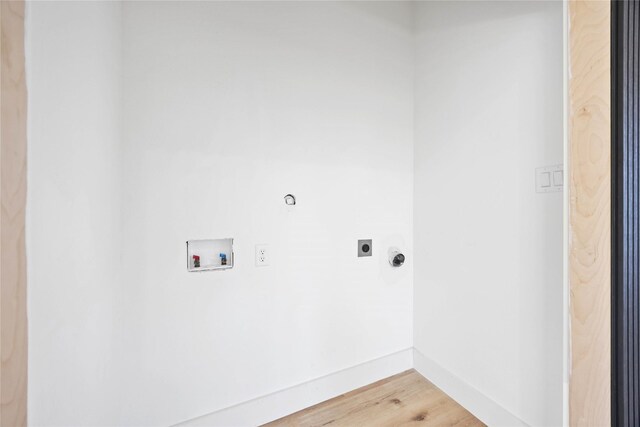 washroom featuring hookup for a washing machine, electric dryer hookup, baseboards, and light wood-style flooring