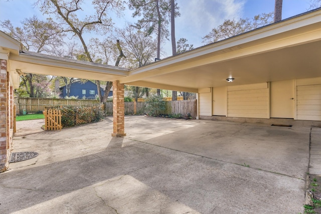 view of patio / terrace featuring fence and a carport