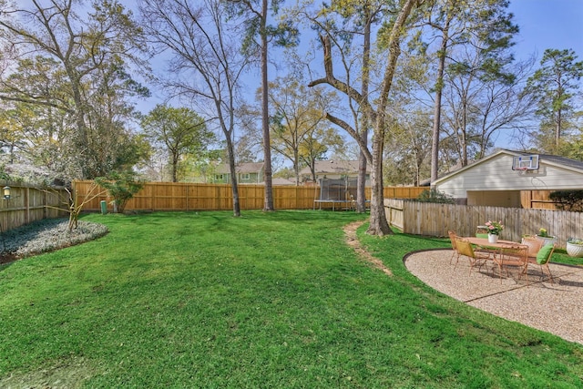 view of yard with a trampoline and a patio area