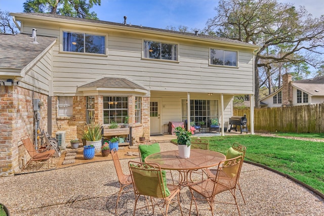 back of house featuring a patio area, outdoor dining space, and brick siding