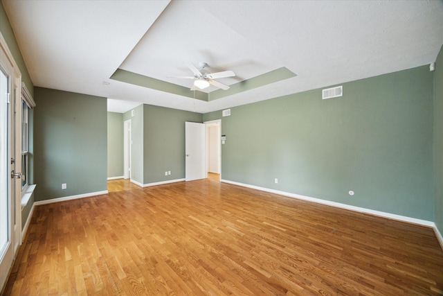 14303 Bonney Brier Dr, Houston, TX 77069 - unfurnished bedroom with a tray ceiling, light wood-style floors, baseboards, and ceiling fan