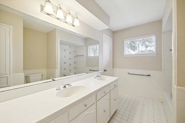 14303 Bonney Brier Dr, Houston, TX 77069 - full bath with tile patterned flooring, toilet, double vanity, wainscoting, and tile walls